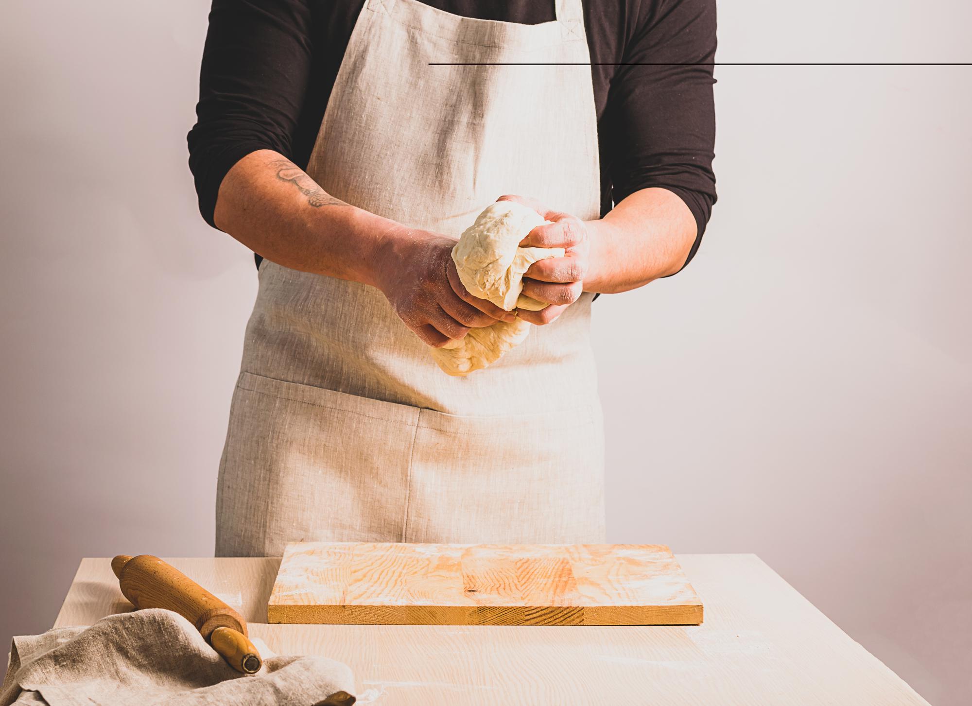 Student preparing fresh pasta on a wooden board